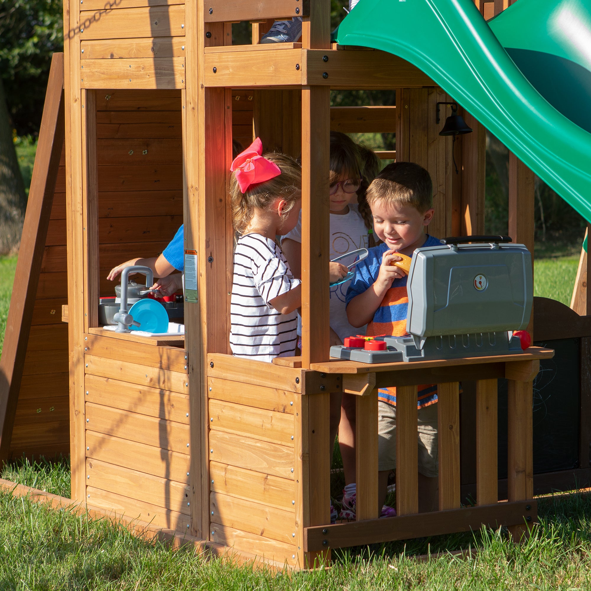 Young kids playing in pretend kitchen